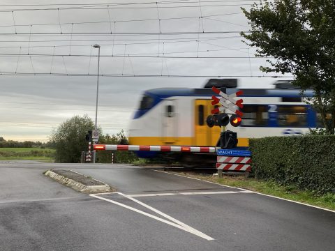 Trein bij spoorwegovergang in Schiedam
