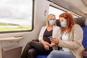 Reizigers met mondkapje in trein (foto: NS)